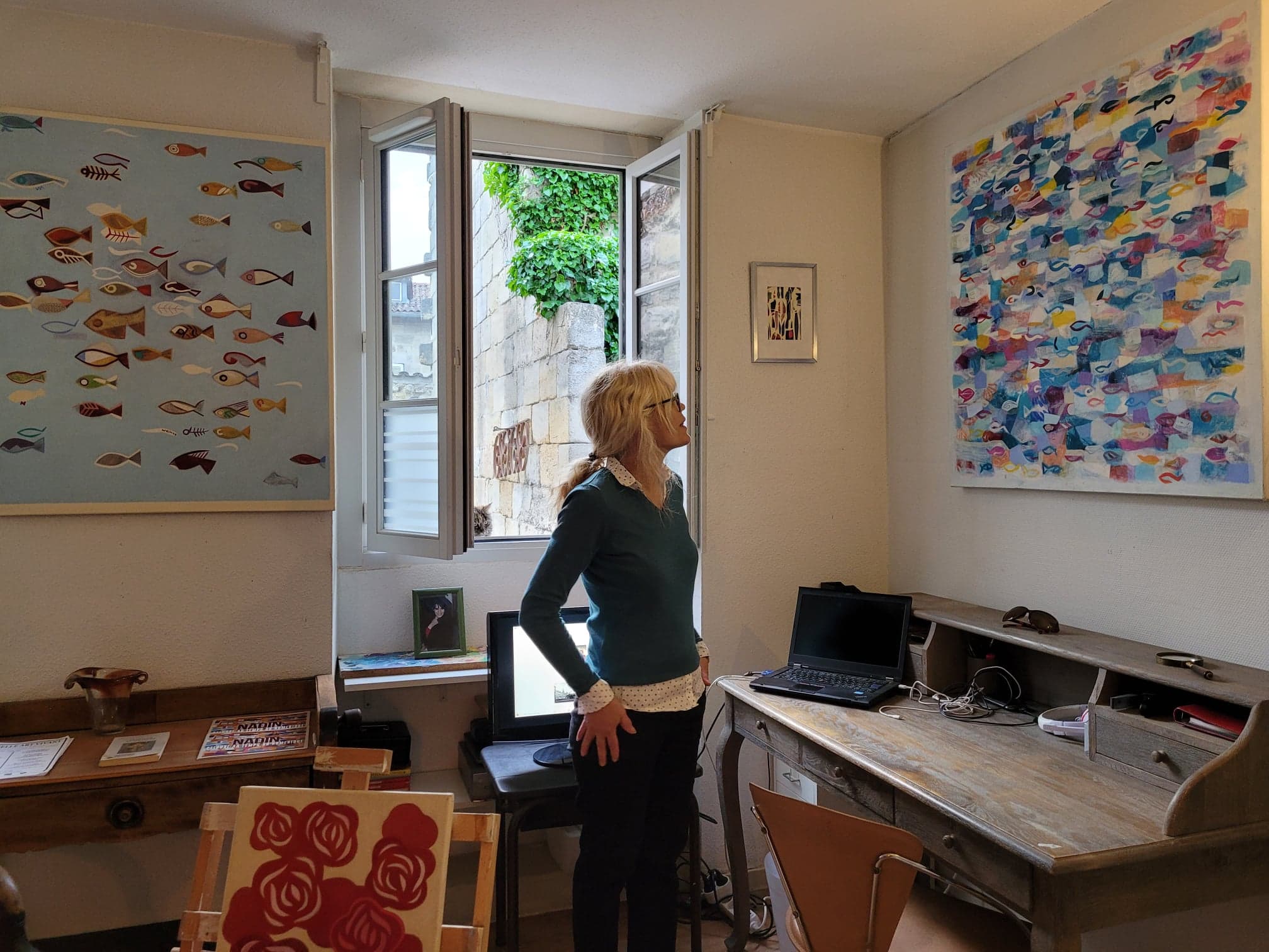 Une visiteuse regarde "Poisson", une toile de S. Nadin faite en 2019 de 100 x 100 cm
