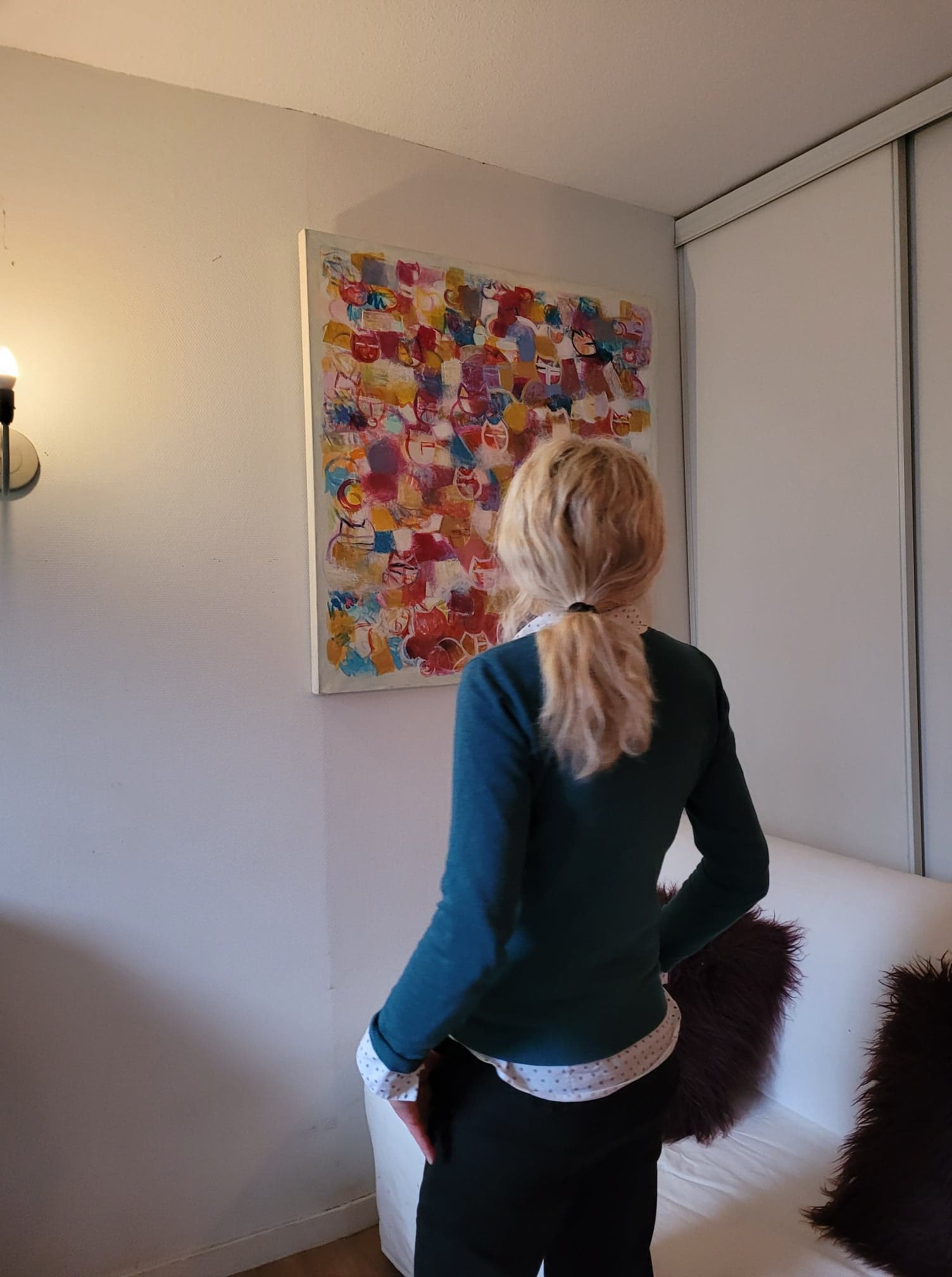 Une visiteuse regarde "Chats", une toile de S. Nadin faite en 2019 de 100 x 100 cm
